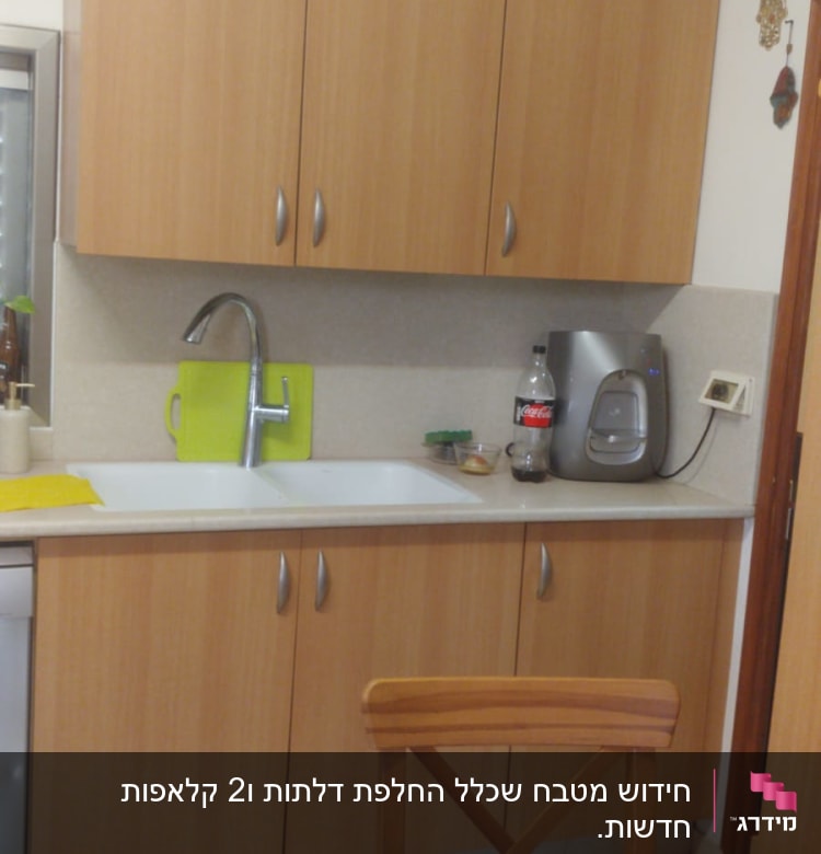 מטבח עם ארונות עץ, כיור וברז, בקבוק קולה